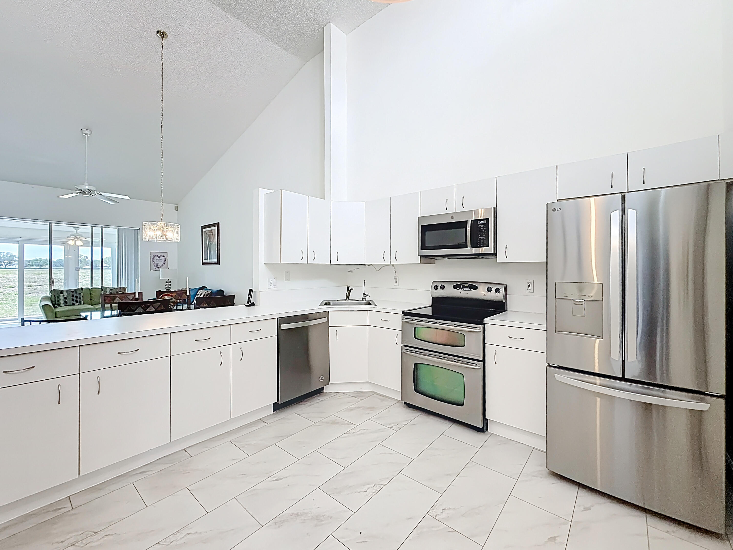 10954 Lakemore Lane Boca Raton, FL 33498 - Photo 12 of 61 a kitchen with white cabinets stainless steel appliances and a window