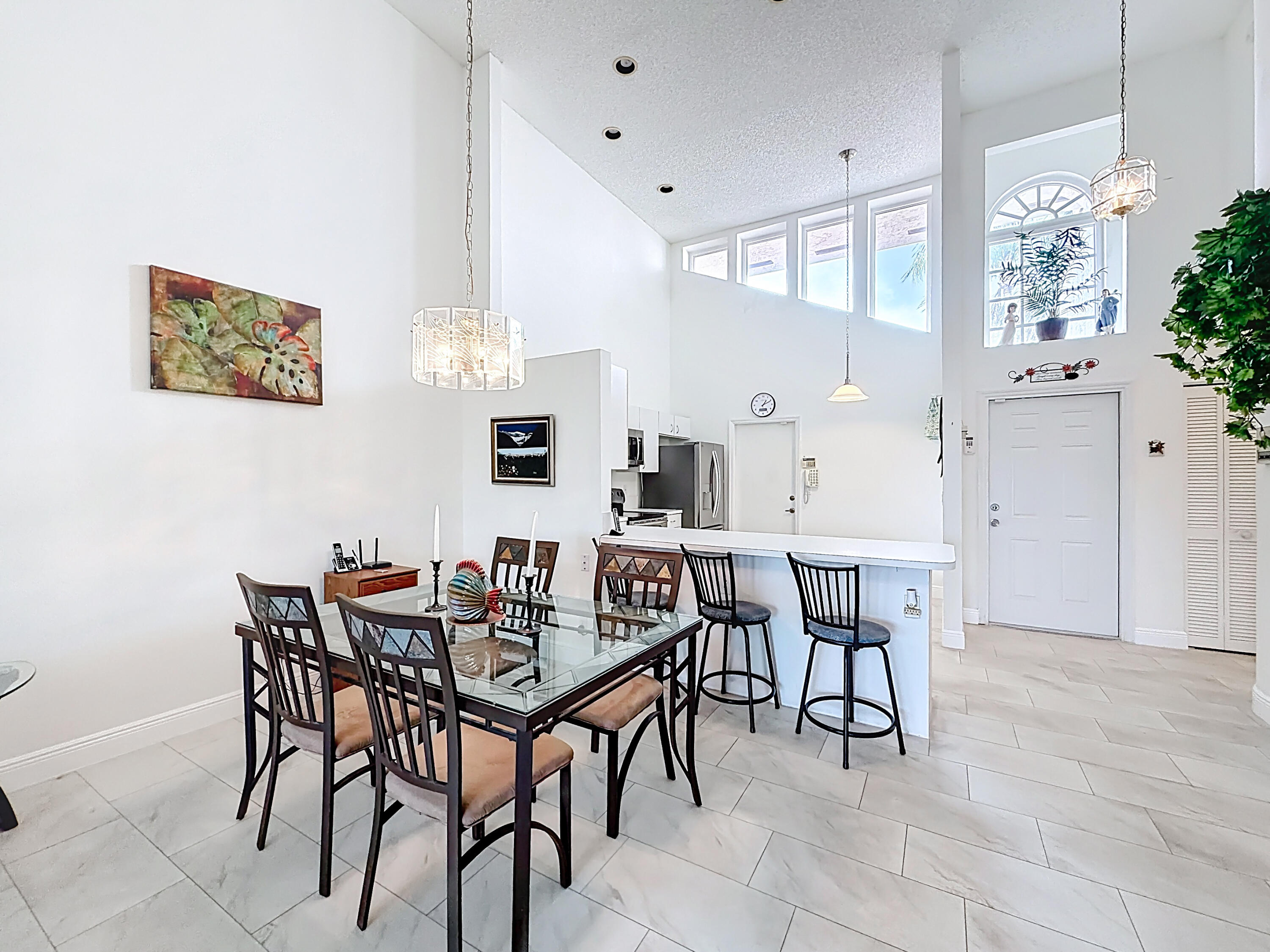 10954 Lakemore Lane Boca Raton, FL 33498 - Photo 18 of 61 a view of a dining room and livingroom with furniture wooden floor a rug a painting and a chandelier