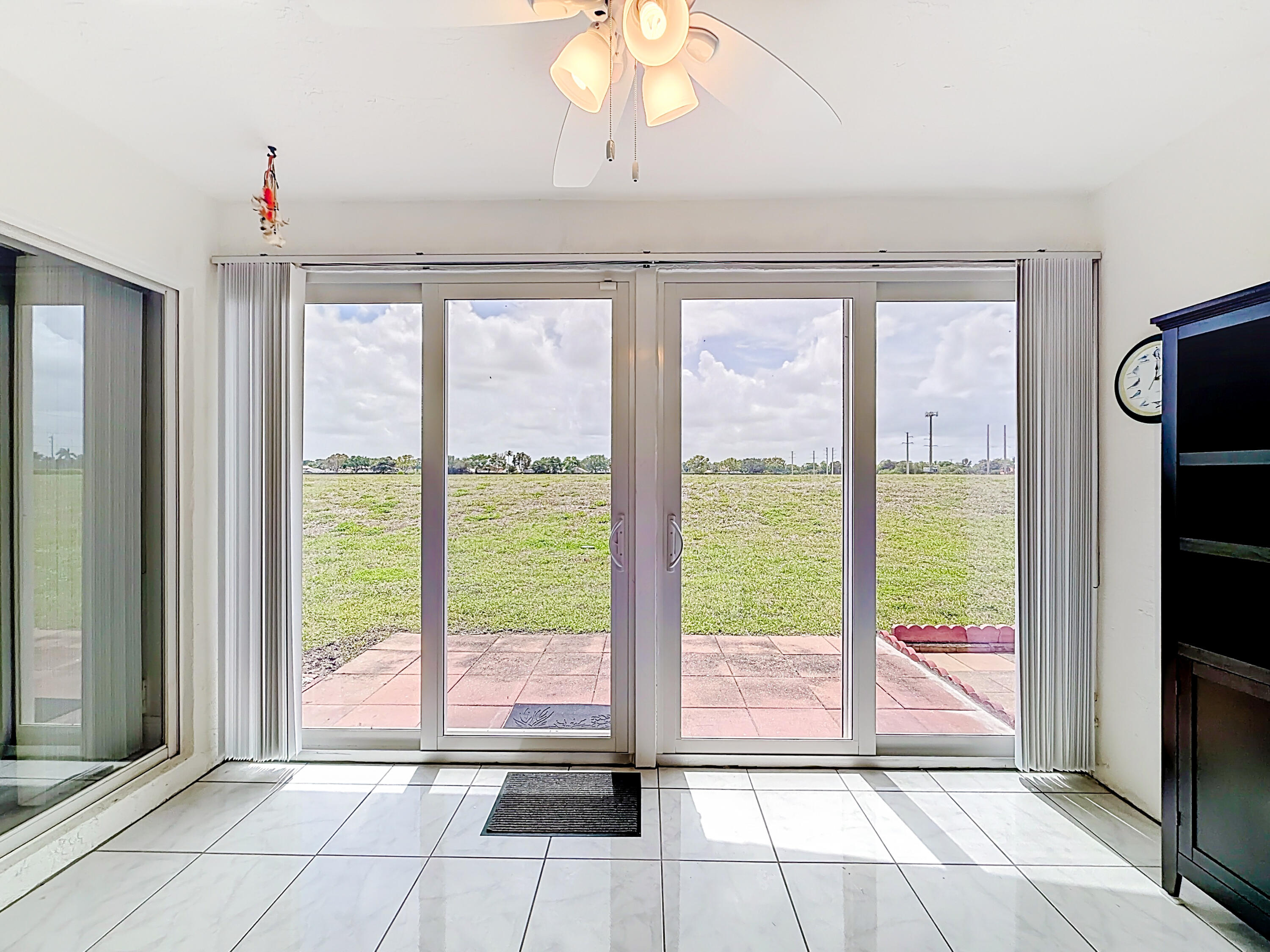 10954 Lakemore Lane Boca Raton, FL 33498 - Photo 24 of 61 a view of hallway with a floor to ceiling window and a kitchen