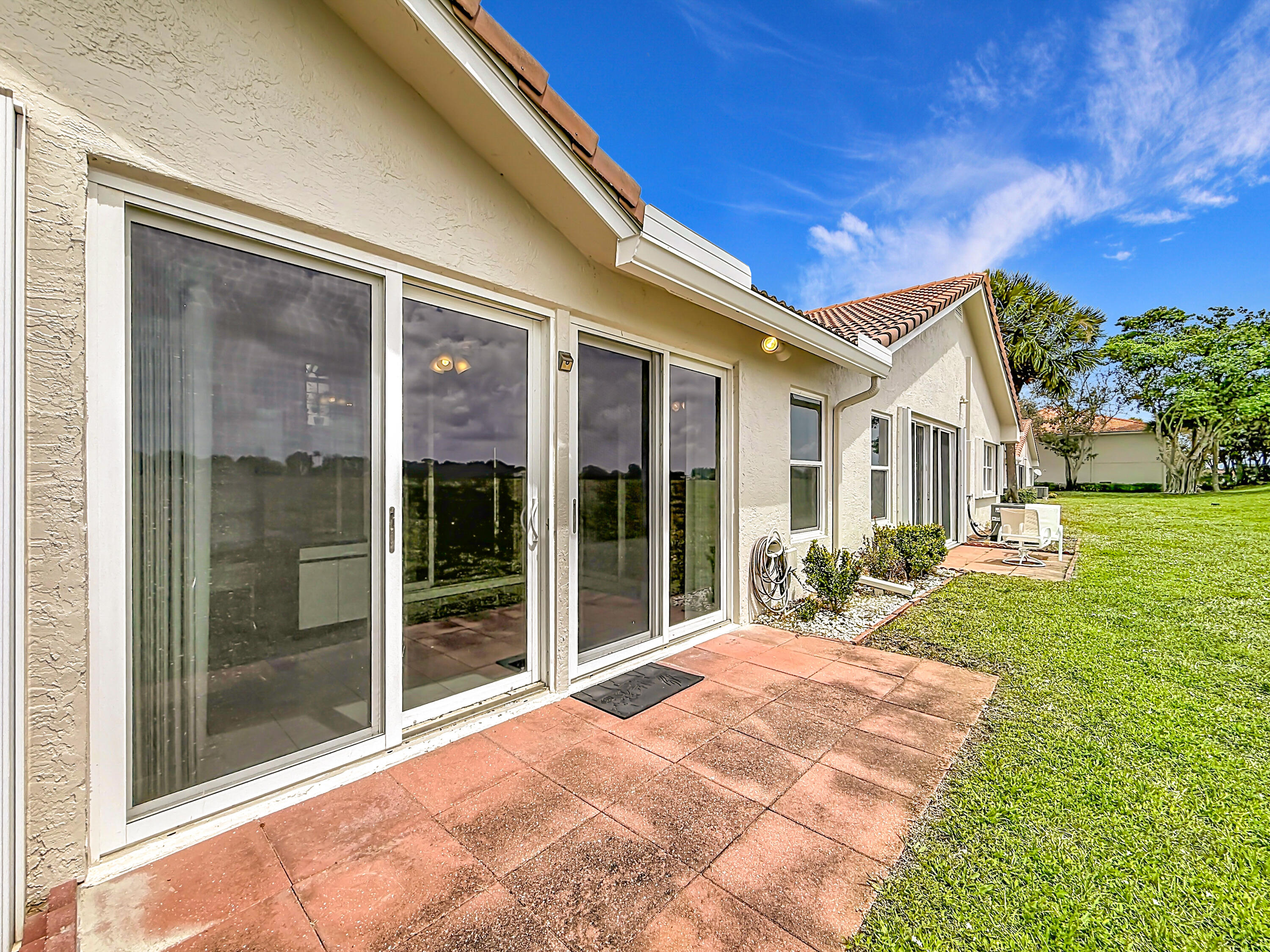 10954 Lakemore Lane Boca Raton, FL 33498 - Photo 53 of 61 a view of a house with a large window and a yard