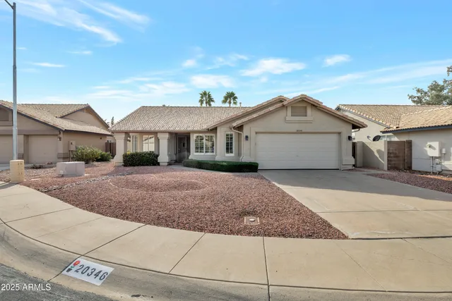 a front view of a house with garage and yard
