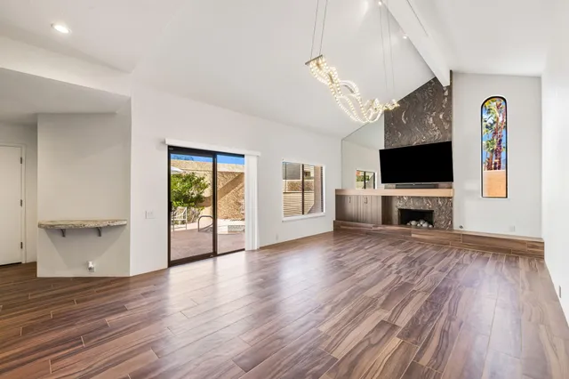 a view of a livingroom with a flat screen tv wooden floor and a ceiling fan