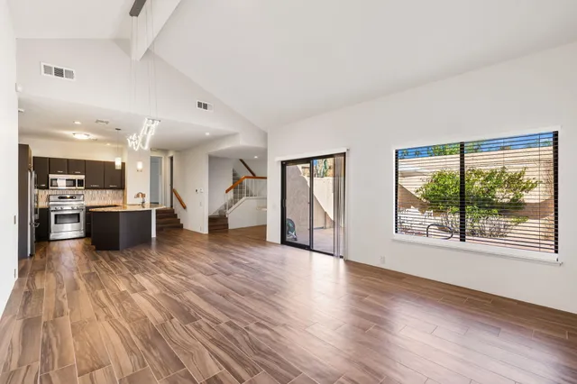 a view of a livingroom with wooden floor and a flat screen tv