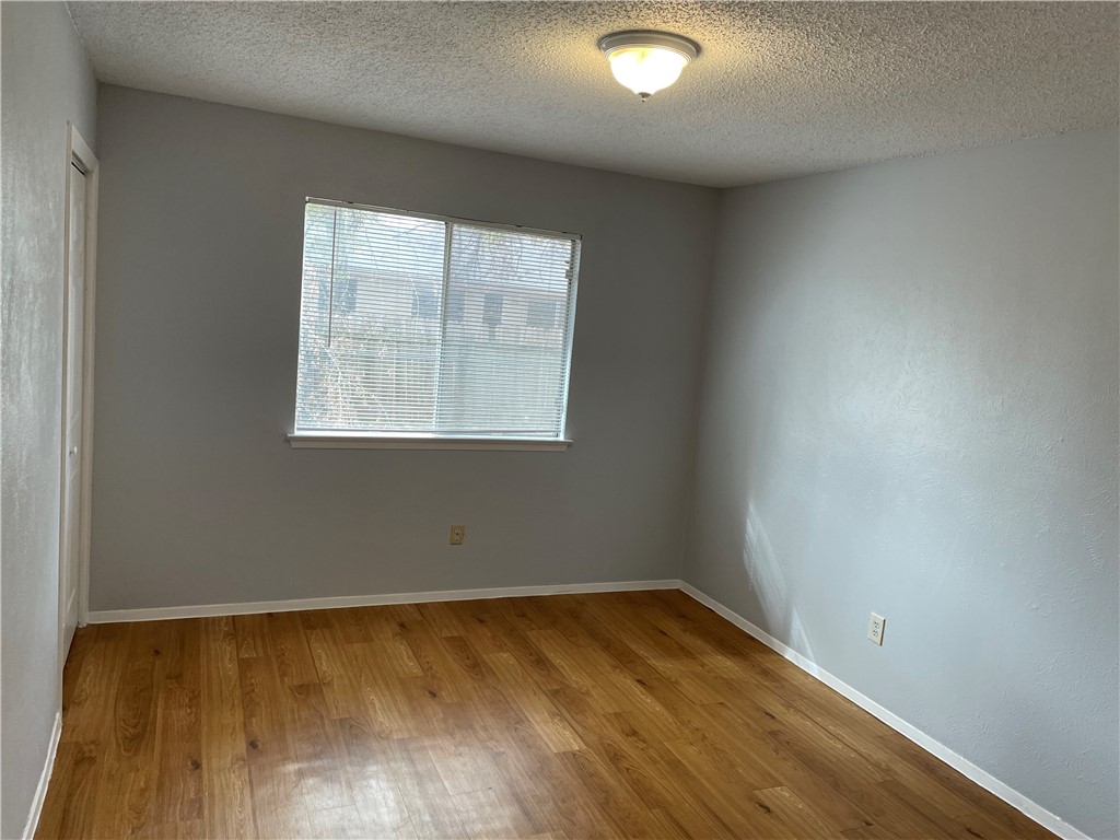105 Meteor Drive, Unit A Austin, TX 78745 - Photo 4 of 23 an empty room with wooden floor and windows