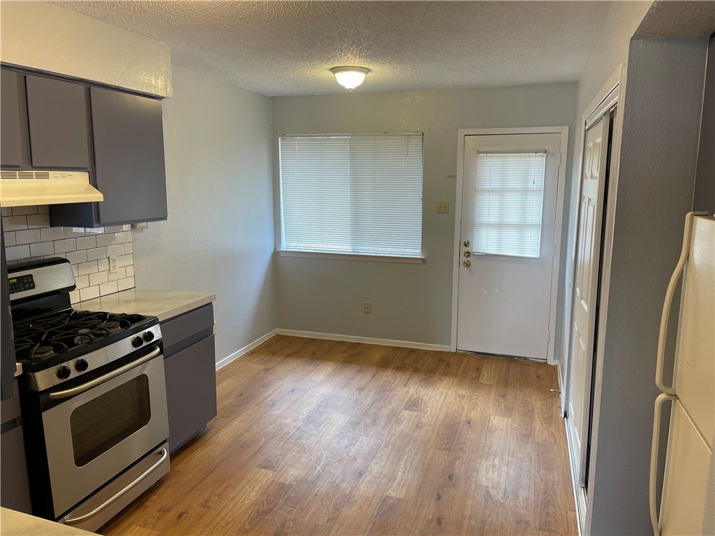 105 Meteor Drive, Unit A Austin, TX 78745 - Photo 8 of 23 a kitchen with granite countertop a stove and a wooden floor