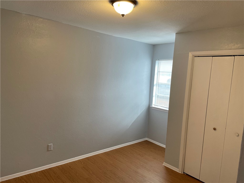 105 Meteor Drive, Unit A Austin, TX 78745 - Photo 9 of 23 an empty room with wooden floor and windows