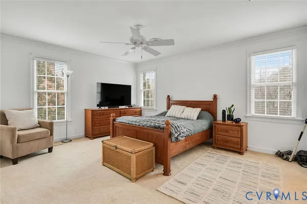 a bedroom with a bed a couch and a flat screen tv