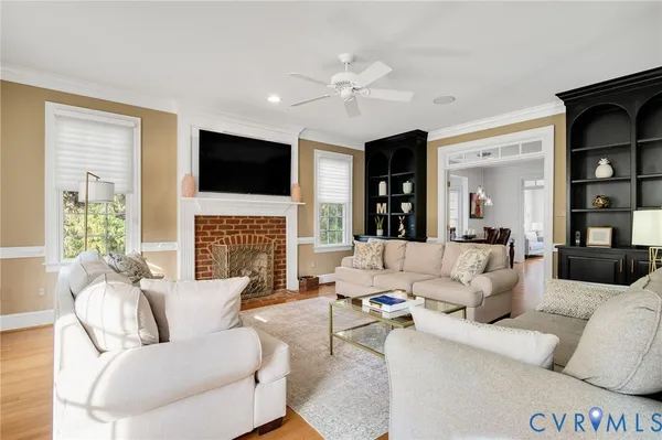 a living room with furniture a fireplace and a flat screen tv