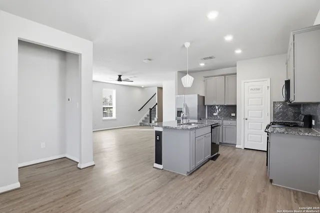 a kitchen with sink a stove and cabinets