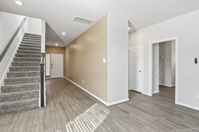 a view of a hallway with wooden floor and entryway