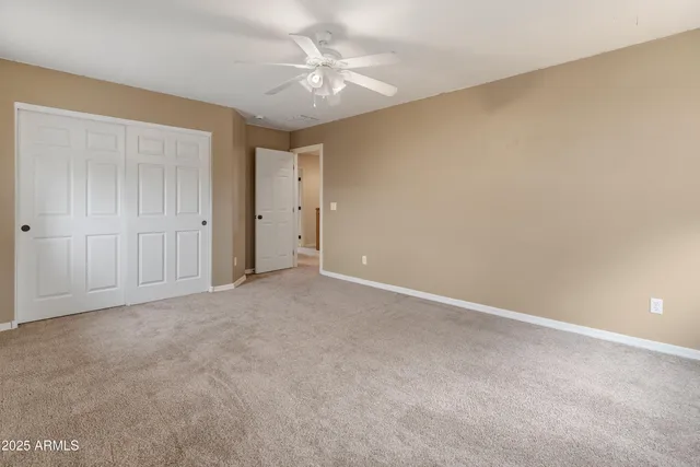 an empty room with a ceiling fan and a window