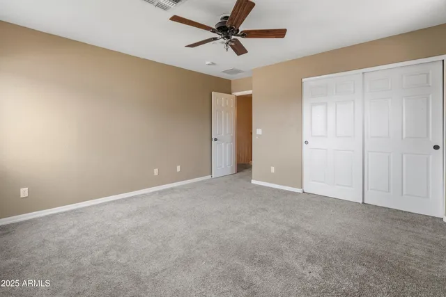 a view of an empty room and a ceiling fan
