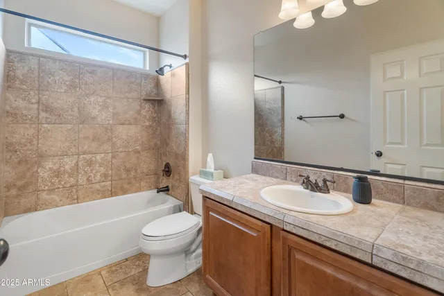 a bathroom with a granite countertop sink mirror toilet and bathtub
