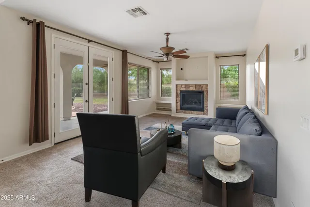 a living room with furniture a fireplace and a large window