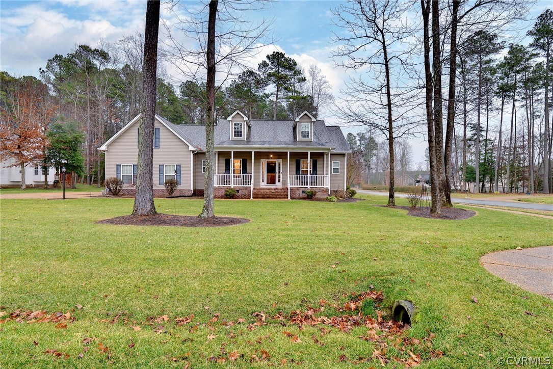 a front view of a house with garden and trees