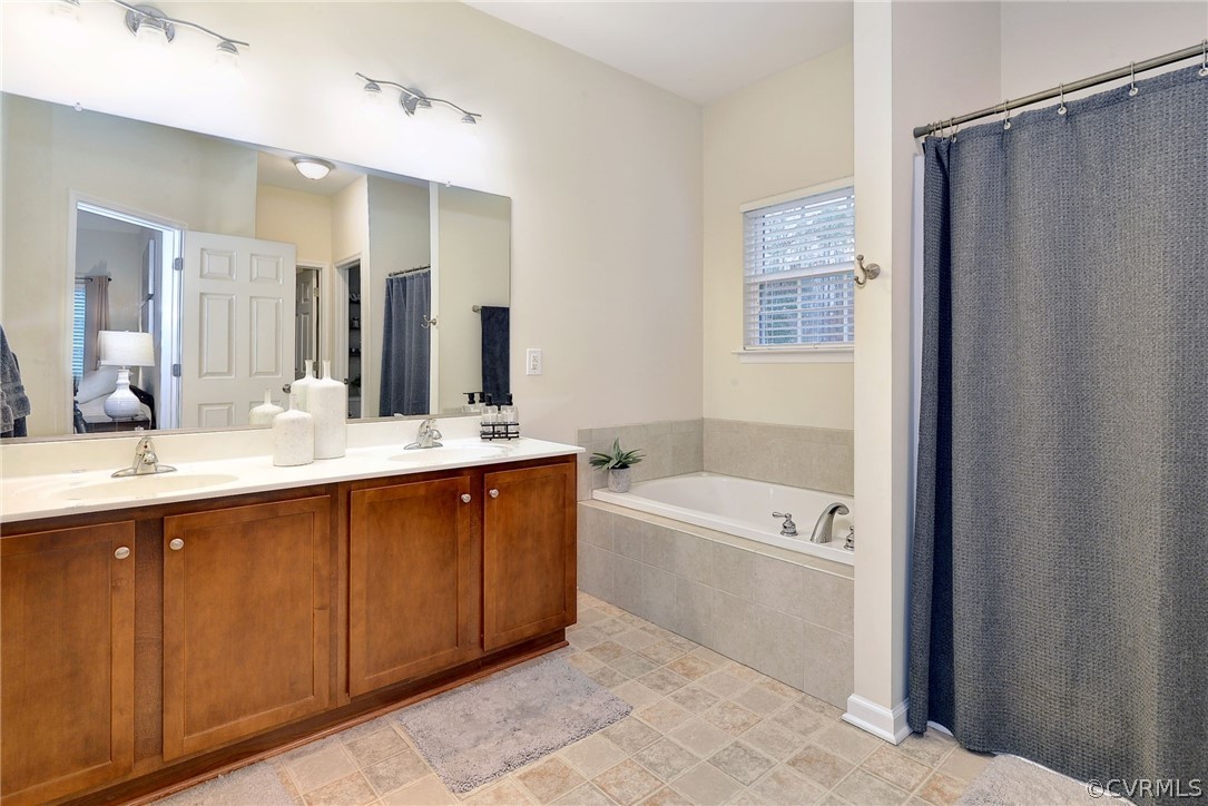 8343 Patrick Henry Way Gloucester, VA 23061 - Photo 23 of 39 a bathroom with a tub a sink and mirror