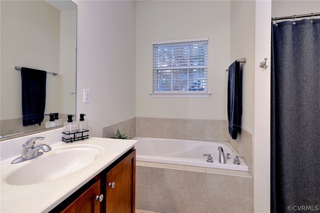 8343 Patrick Henry Way Gloucester, VA 23061 - Photo 24 of 39 a bathroom with a tub sink and a mirror