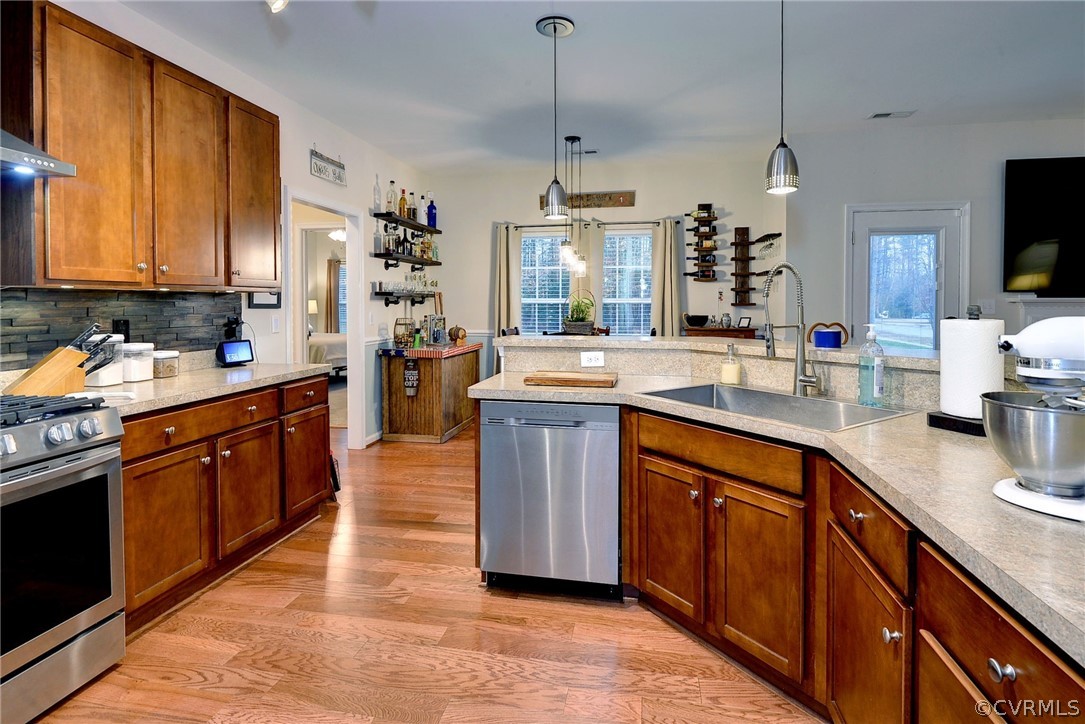 8343 Patrick Henry Way Gloucester, VA 23061 - Photo 8 of 39 a kitchen with stainless steel appliances granite countertop wooden cabinets a sink dishwasher a stove and a refrigerator