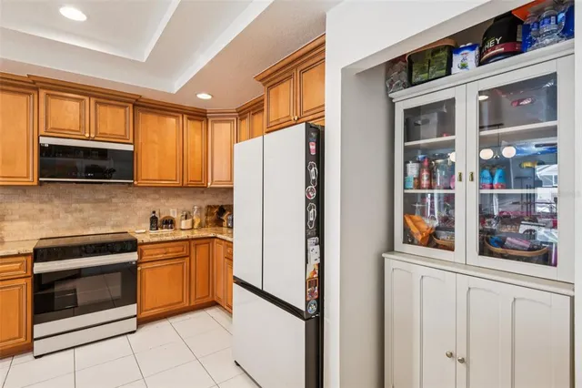 a kitchen with stainless steel appliances granite countertop a refrigerator and a stove top oven