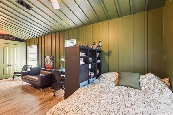 a bedroom with a bed and wooden floor