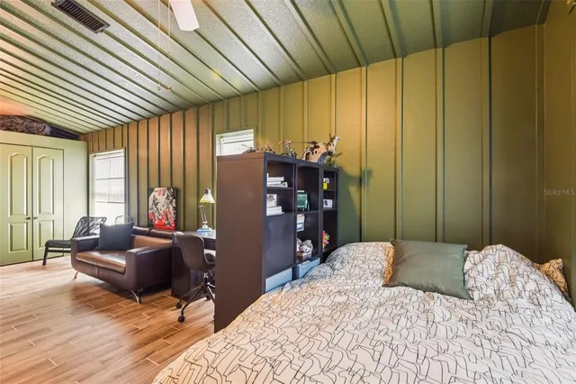 a bedroom with a bed and wooden floor