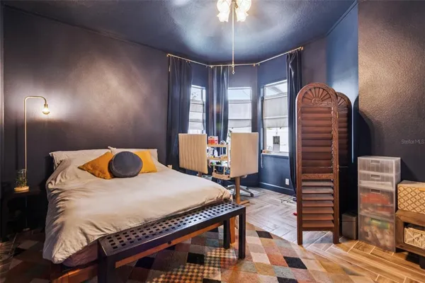 a bedroom with a bed and wooden floor