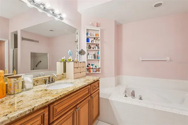 a bathroom with a granite countertop sink mirror and bathtub