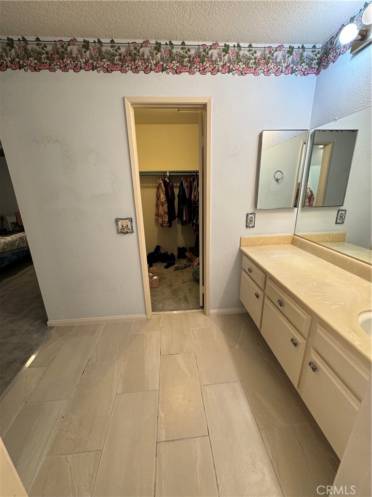 19133 Index Street, Unit 1 Porter Ranch, CA 91326 - Photo 12 of 24 a en suite bathroom with a granite countertop sink and a mirror