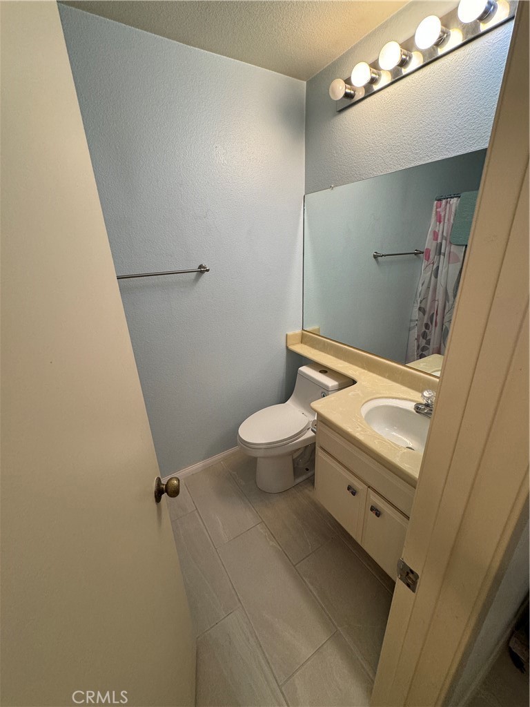 19133 Index Street, Unit 1 Porter Ranch, CA 91326 - Photo 13 of 24 a bathroom with a granite countertop toilet and a sink