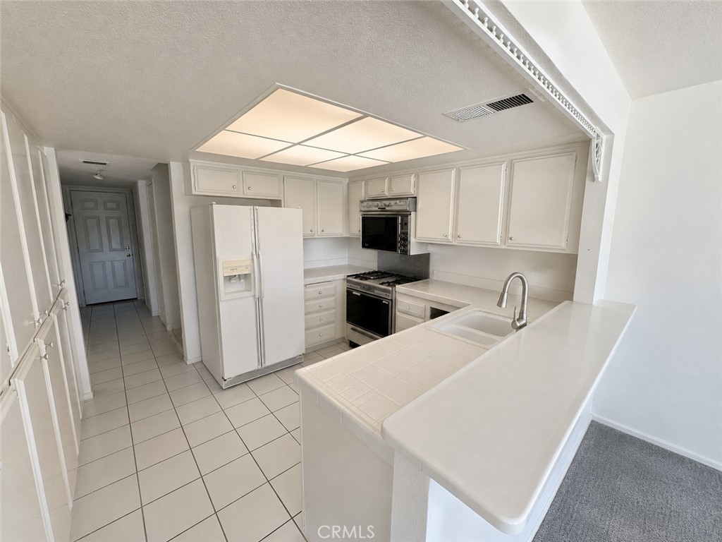 19133 Index Street, Unit 1 Porter Ranch, CA 91326 - Photo 5 of 24 a kitchen with a sink a microwave and refrigerator