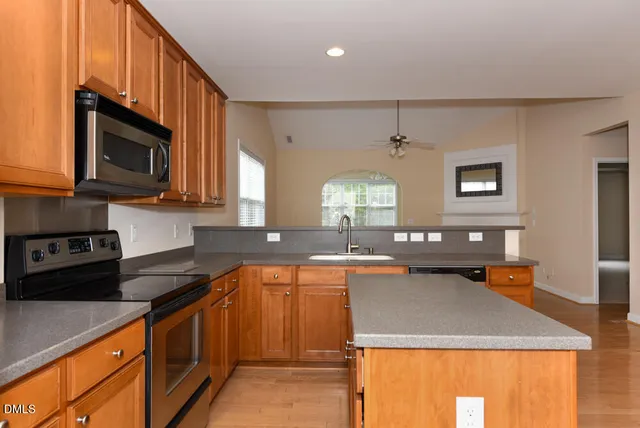 a kitchen with stainless steel appliances granite countertop a sink stove and microwave