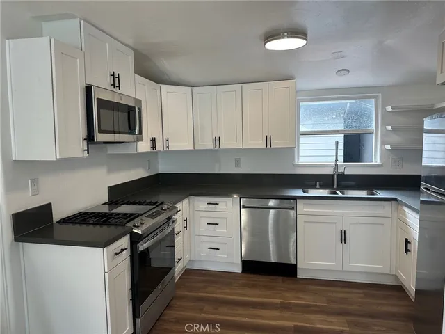 a kitchen with stainless steel appliances a sink stove and microwave