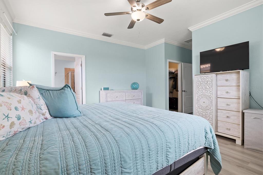 12675 Richezza Drive Venice, FL 34293 - Photo 16 of 60 a bedroom with a large bed and a flat tv screen on dresser