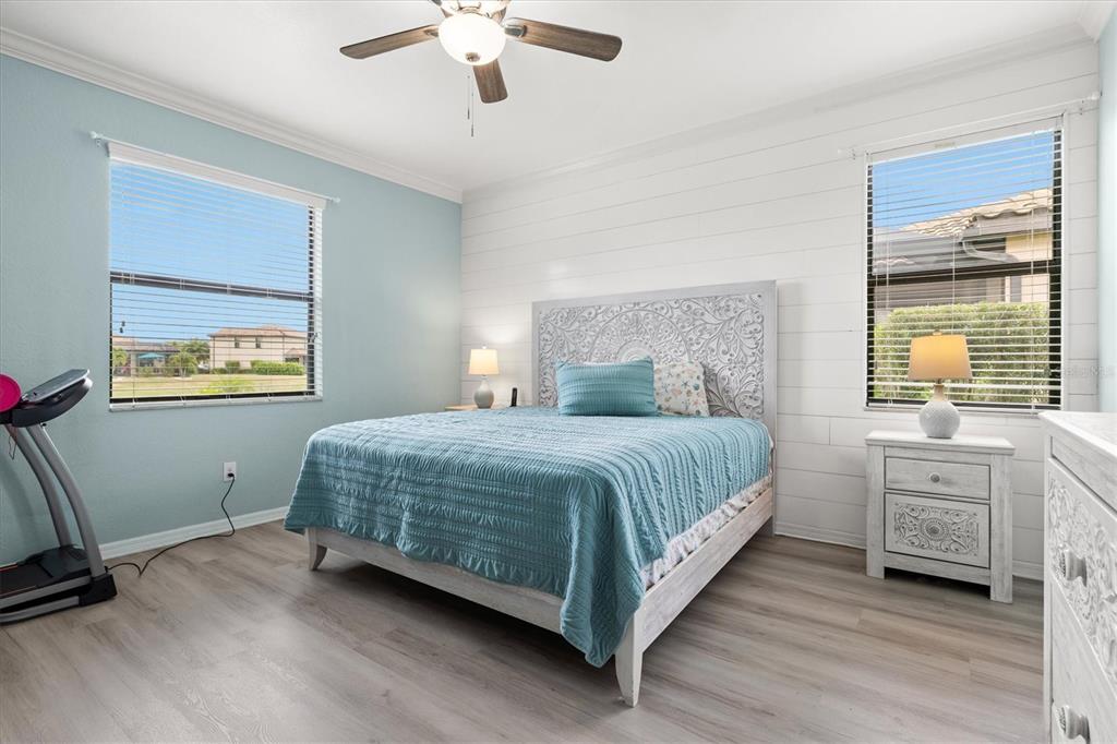 12675 Richezza Drive Venice, FL 34293 - Photo 17 of 60 a bedroom with a large bed and a chandelier