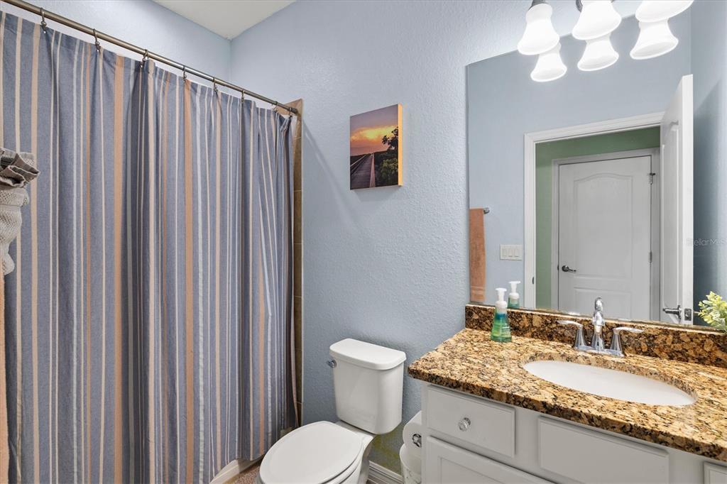 12675 Richezza Drive Venice, FL 34293 - Photo 23 of 60 a bathroom with a granite countertop sink vanity mirror and toilet