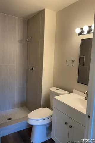 a bathroom with a sink a toilet and shower