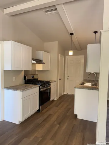 a kitchen with stainless steel appliances granite countertop a stove a sink and a refrigerator