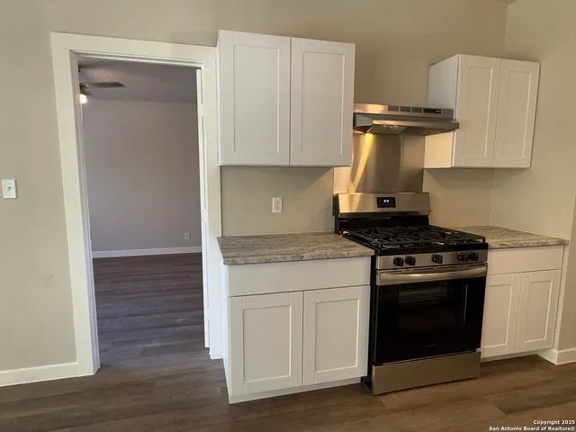 a kitchen with a stove and a wooden cabinets