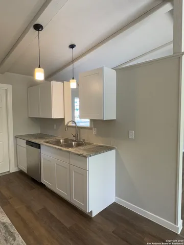 a kitchen with a sink cabinets and wooden floor