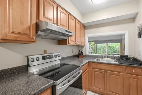 a kitchen with granite countertop a stove sink and cabinets