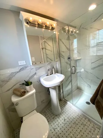 a bathroom with a sink mirror toilet and shower