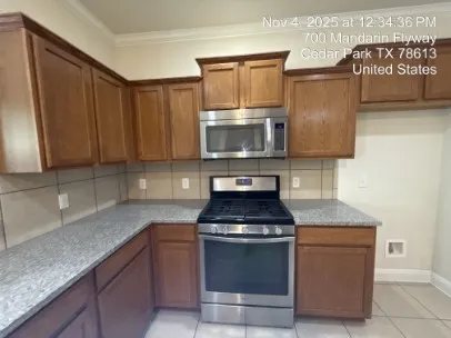 a kitchen with granite countertop wood cabinets and stainless steel appliances