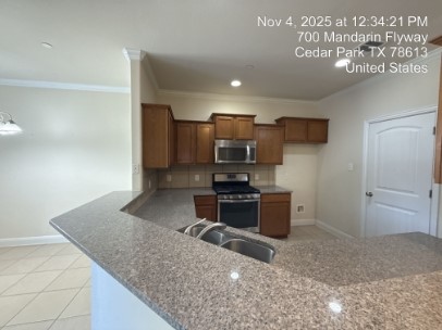 700 Mandarin Flyway, Unit 502 Cedar Park, TX 78613 - Photo 5 of 25 a kitchen with a refrigerator and a sink