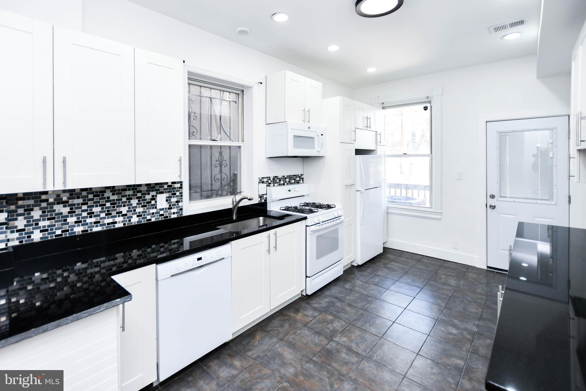 104 R Street Northeast, Unit A Washington, DC 20002 - Photo 14 of 43 a kitchen with granite countertop a sink stove and cabinets