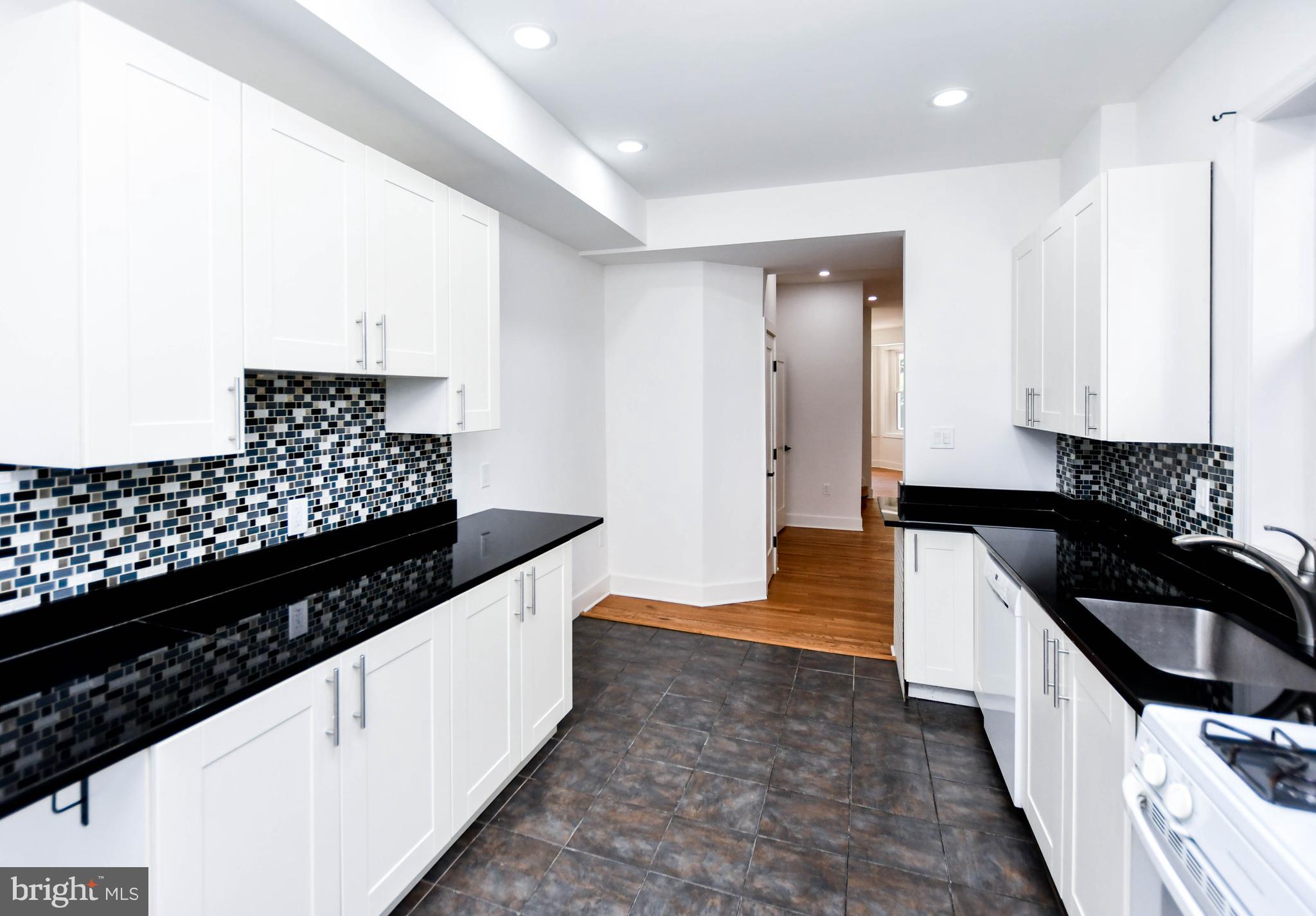 104 R Street Northeast, Unit A Washington, DC 20002 - Photo 18 of 43 a kitchen with granite countertop a sink and cabinets