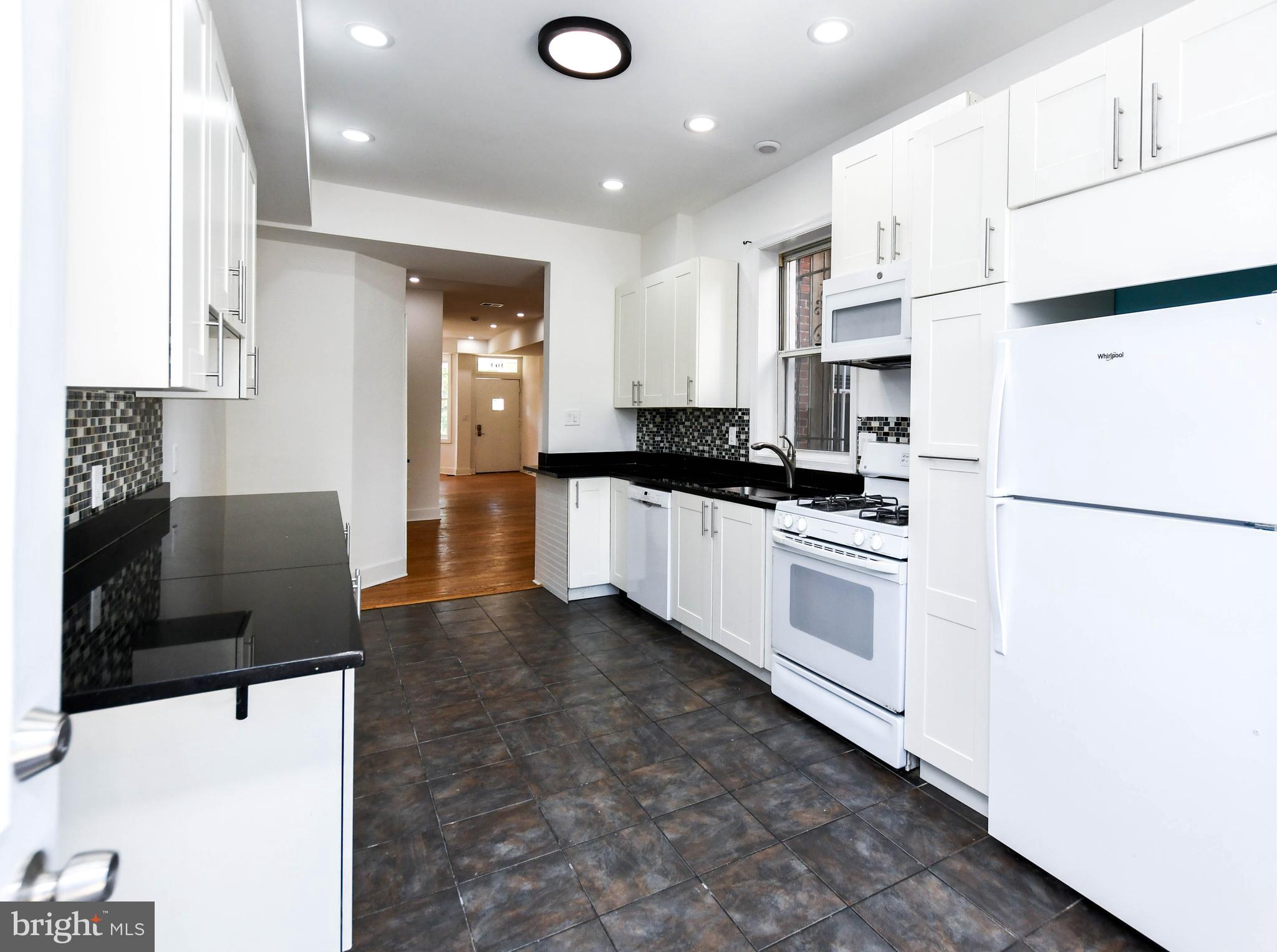 104 R Street Northeast, Unit A Washington, DC 20002 - Photo 19 of 43 a kitchen with stainless steel appliances a refrigerator stove microwave and cabinets