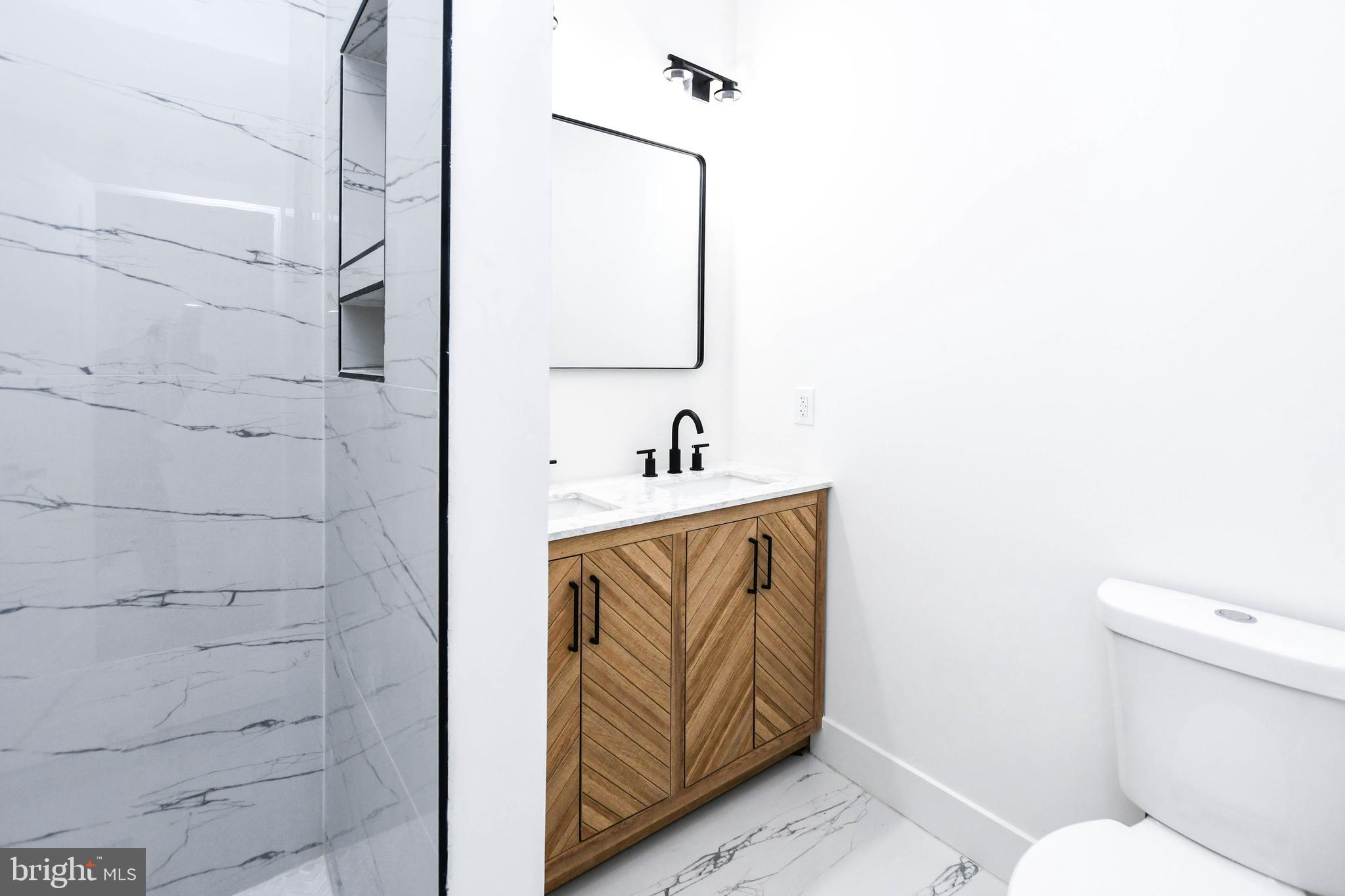 104 R Street Northeast, Unit A Washington, DC 20002 - Photo 31 of 43 a bathroom with a sink a toilet and shower