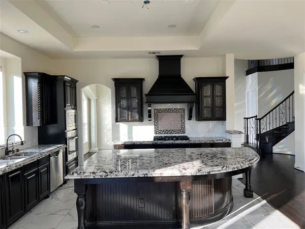 a kitchen with a stove a sink and a wooden cabinets