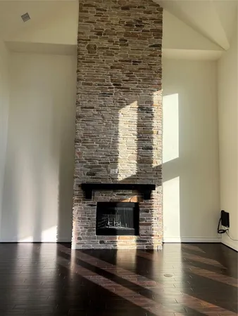 a view of empty room with wooden floor and fireplace
