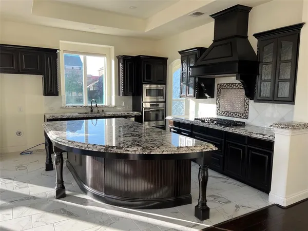 a kitchen with granite countertop a stove and cabinets